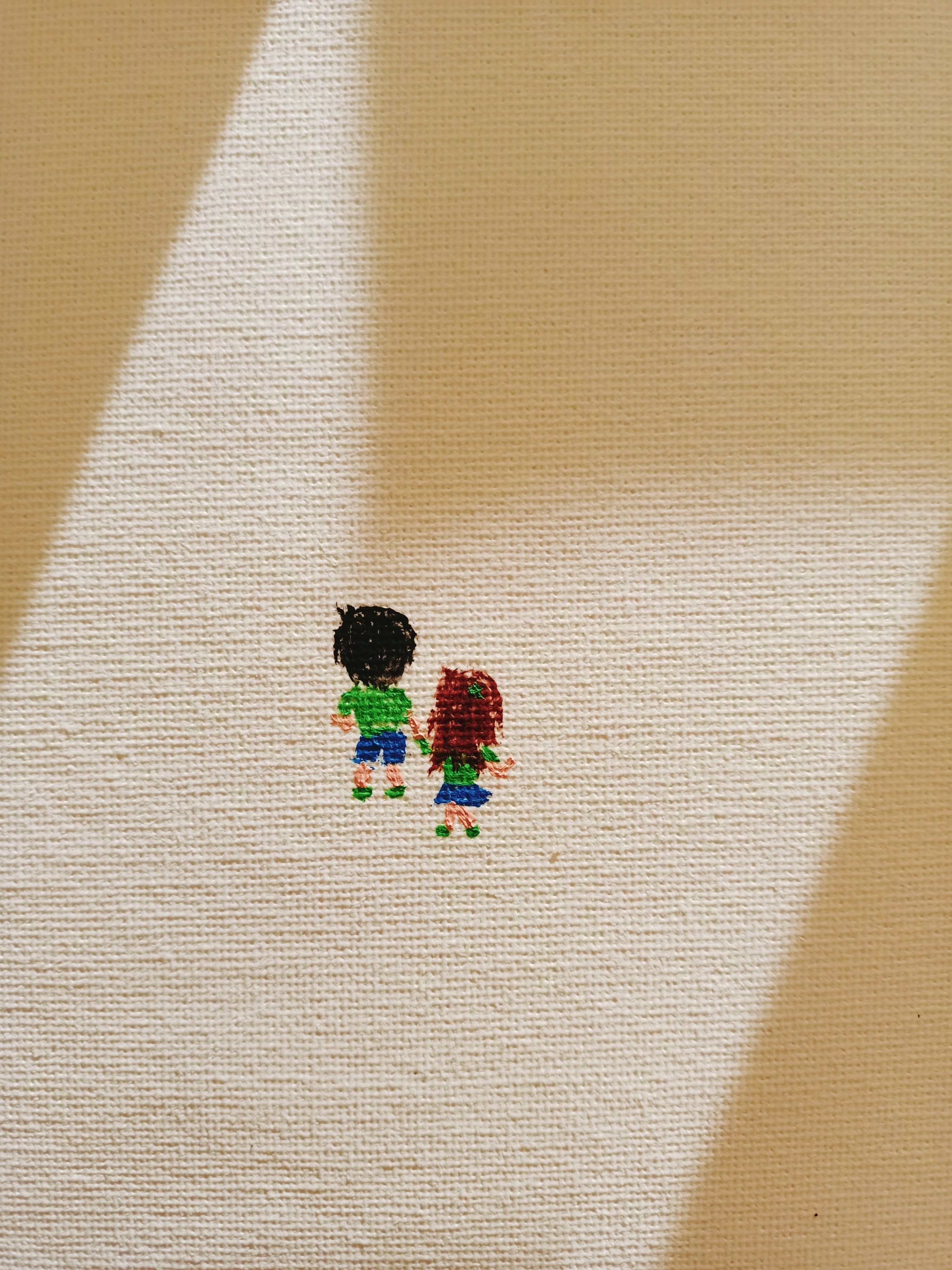 Minimalist hand-drawn illustration of two tiny figures standing side by side on a pale pathway, surrounded by large geometric areas of warm beige, cream and golden brown.